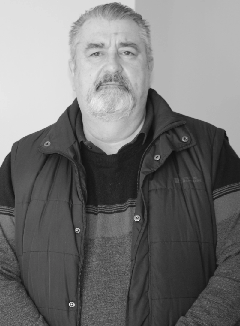Black-and-white portrait of a man wearing a quilted gilet