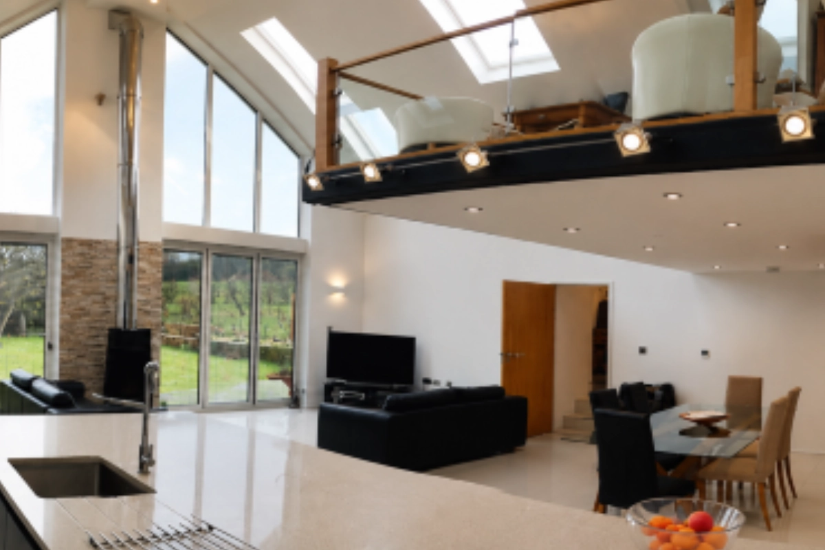 Modern open-plan kitchen, dining and living area with skylights, large windows and contemporary lighting.