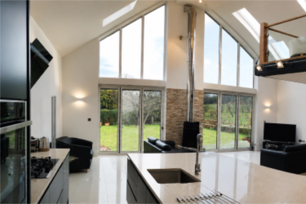 Modern open-plan home extension with a kitchen, living area, wood-burning stove and large garden-facing windows.